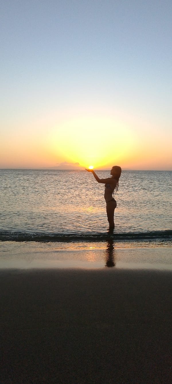 Woman poses with sunset at Juan Griego beach