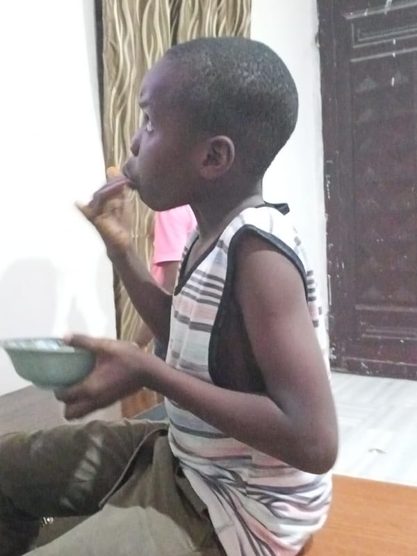 Child eating in striped shirt observed in Zango-ndaji, Nigeria