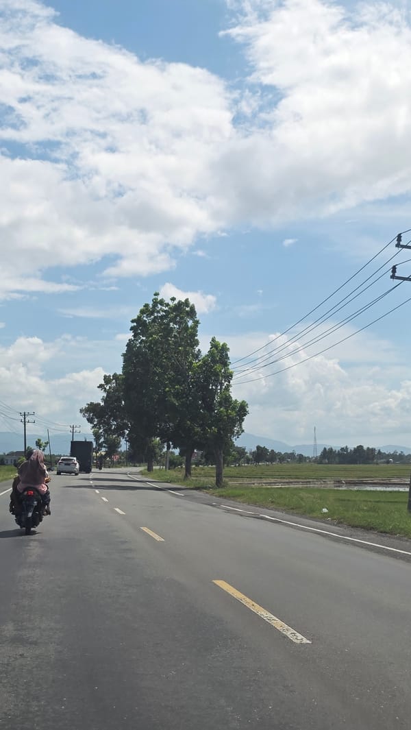 Motorcycle travels rural road in Kampungjumpa, Indonesia morning commute