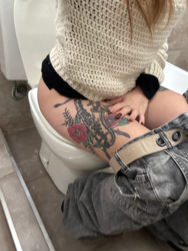 Bathroom scene with visible tattoo documented in Cordoba