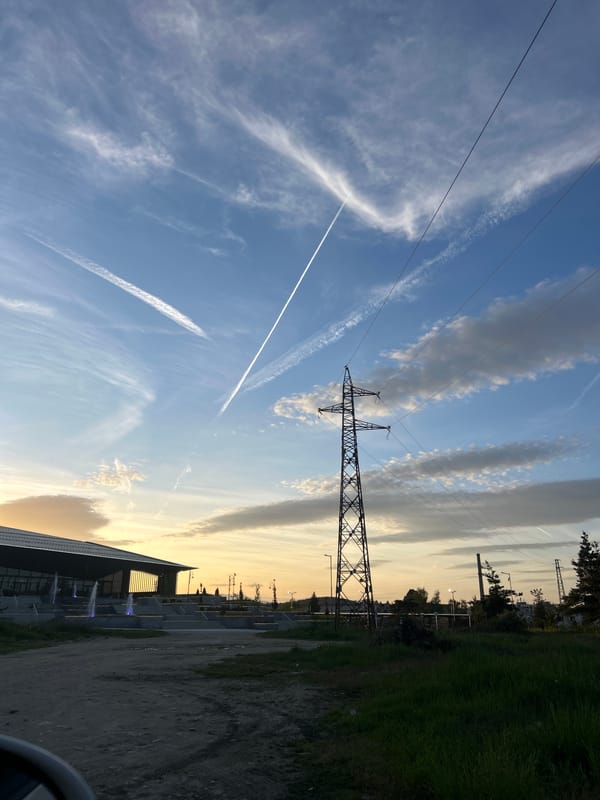 Electrical transmission tower observed under partly cloudy sky