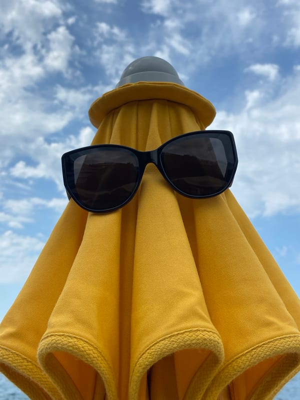 Black sunglasses spotted on yellow umbrella in Montenegro