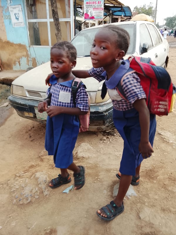 Morning commute on dirt roads in Abuja captures students, motorcyclists