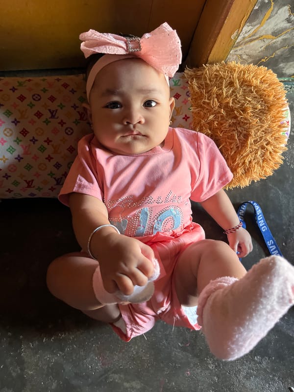 Baby in pink outfit resting at home in Kruengmate