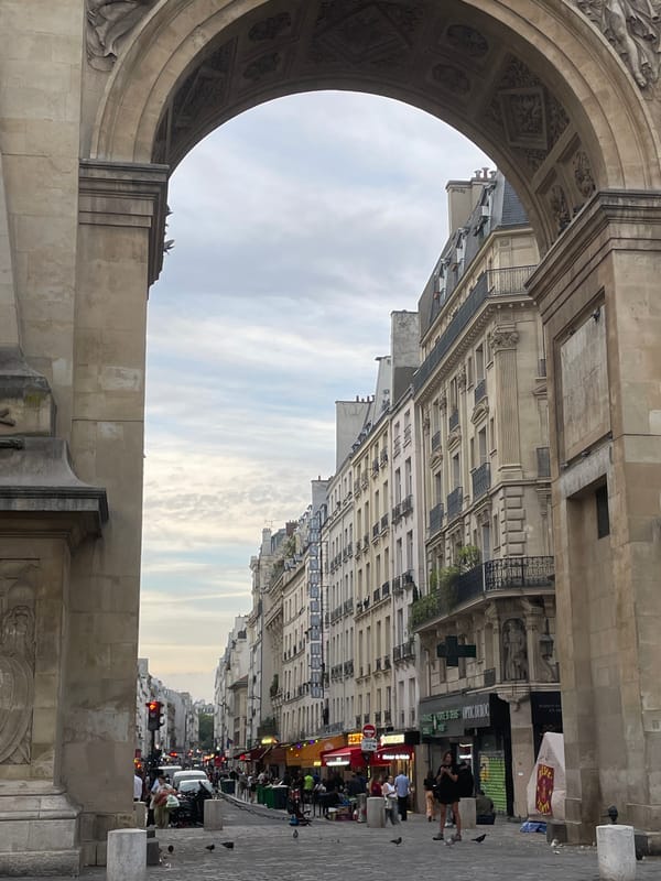 Evening street scenes documented at Paris's Porte Saint-Denis arch