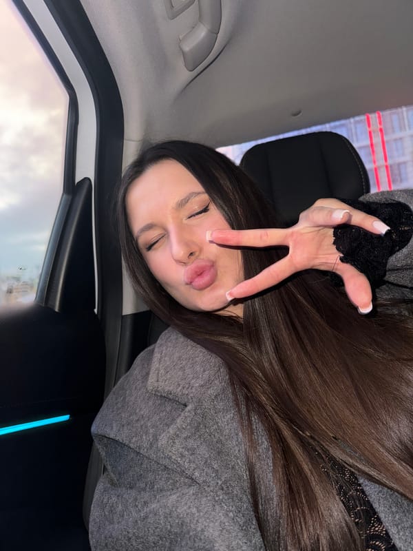 Woman in car makes peace sign in Moscow