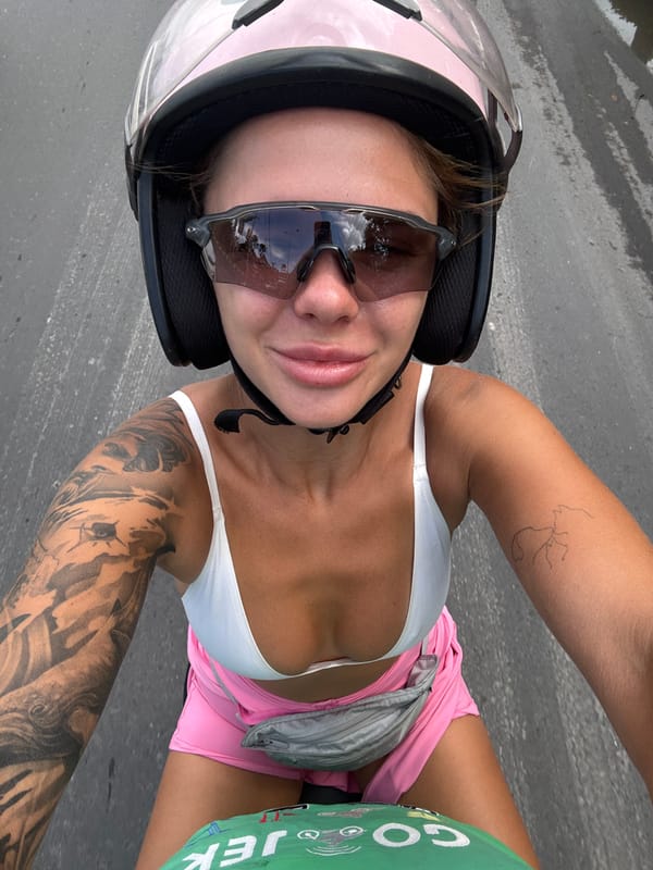 Woman in pink helmet takes selfie in Denpasar