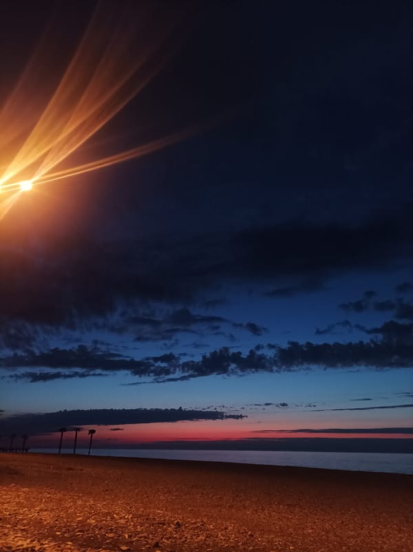 Dusk streetlight illuminates Batumi beach scene in Georgia