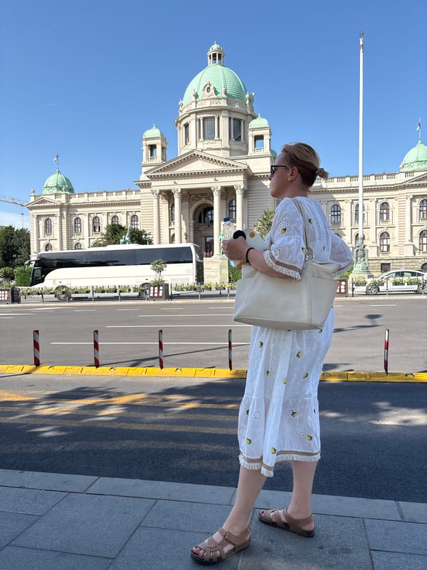 Afternoon street life near Belgrade's green-domed historic building