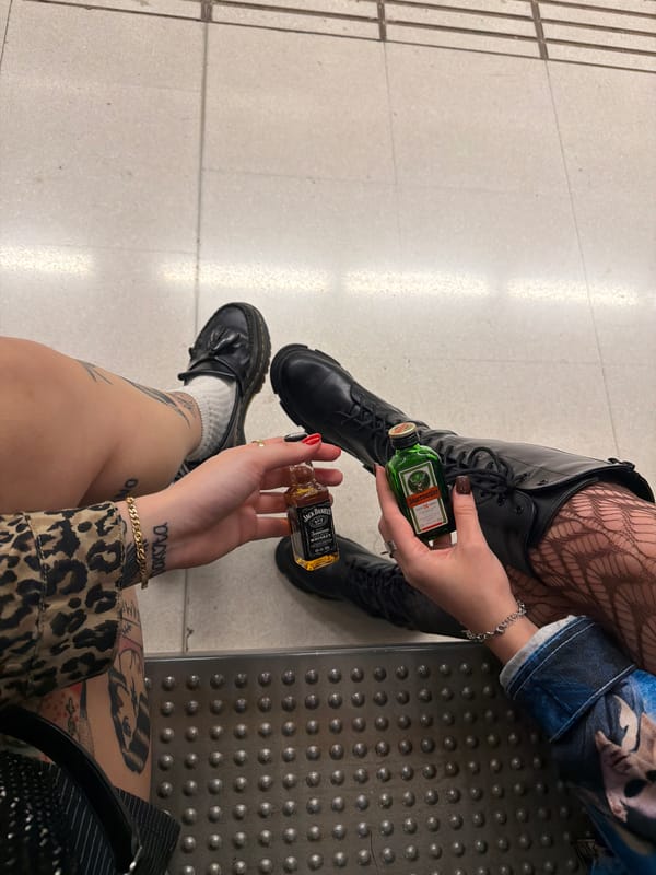 Two people wait at transit stop in Badalona