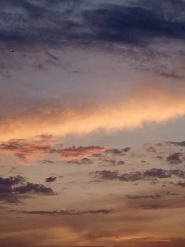 City sunset watched across two hours, clouds doing their thing