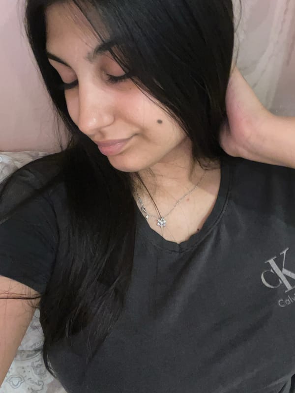 Person takes casual bedroom selfies in dark shirt