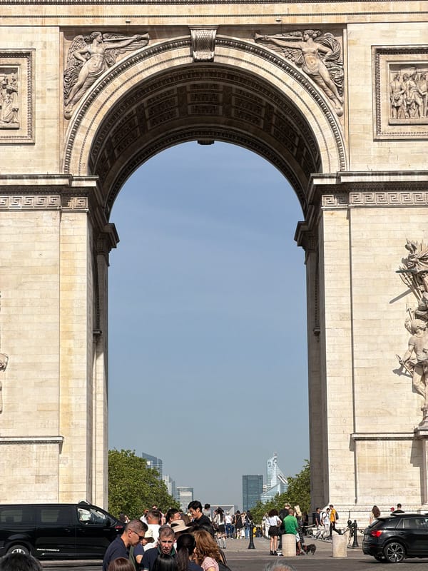 Street musician performs saxophone near Arc de Triomphe
