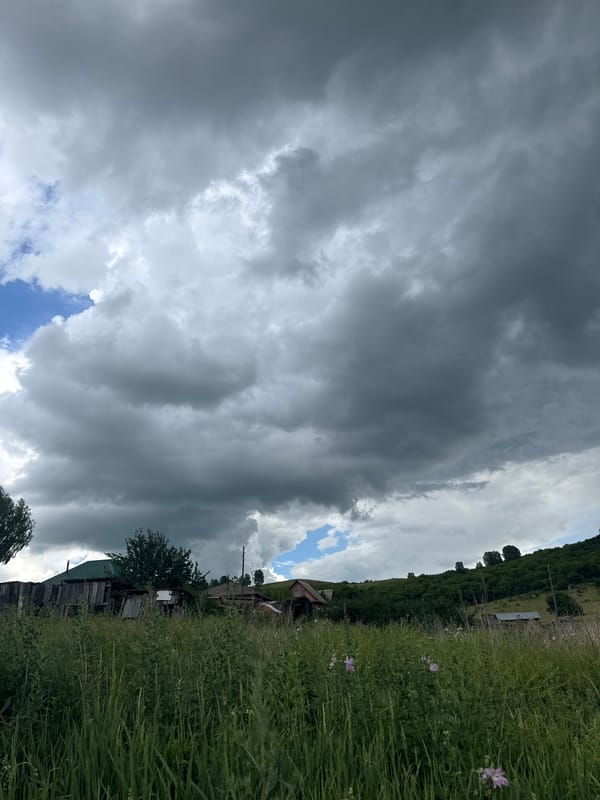 Storm clouds gather over rural Soloneshnoye fields and hills