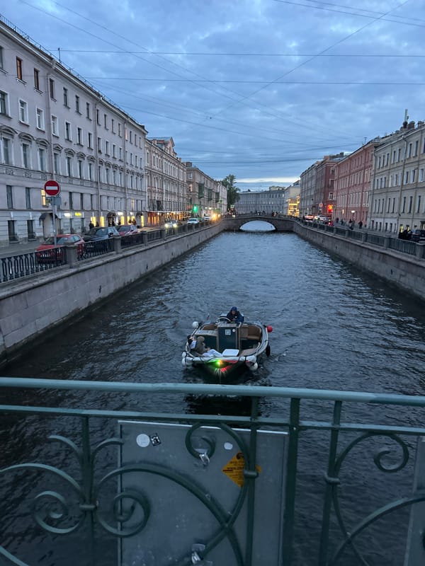 European canal at dusk, boats and evening street life