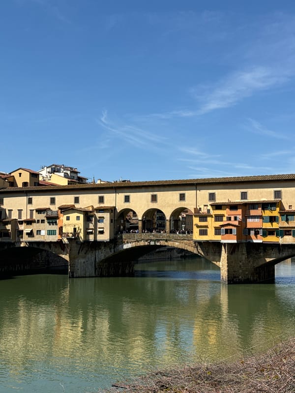 Tourist photographs historic Ponte Vecchio bridge in Florence