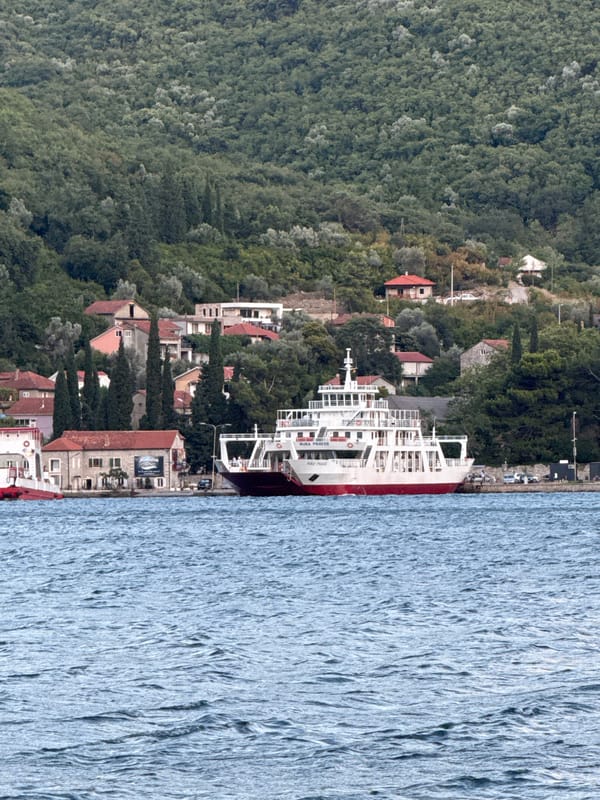 Ferry, sailboats, and summer activity on the Bay of Kotor
