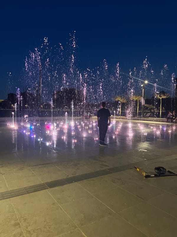 Person interacts with illuminated fountain in Ramat Gan