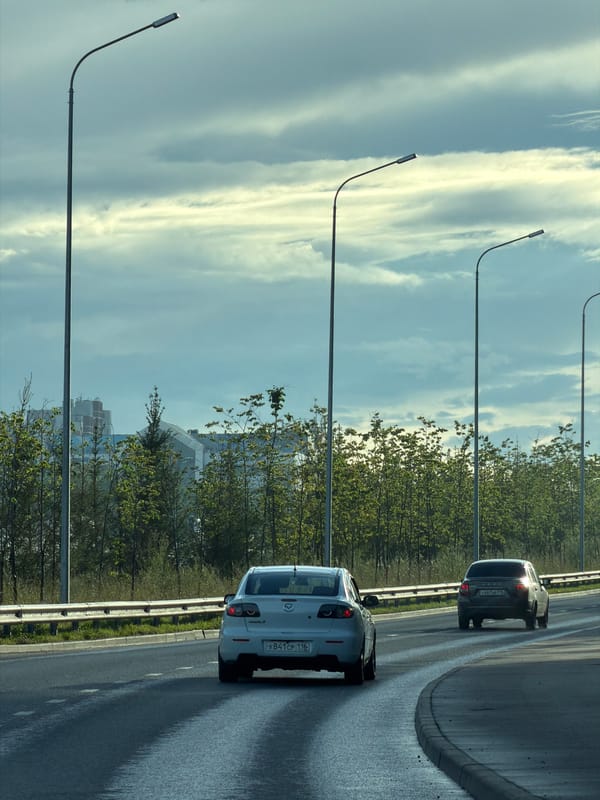White Mazda 3 navigates wet Kazan highways on a cloudy afternoon