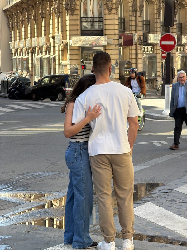 Parisians reflected in storefront windows during midday shopping