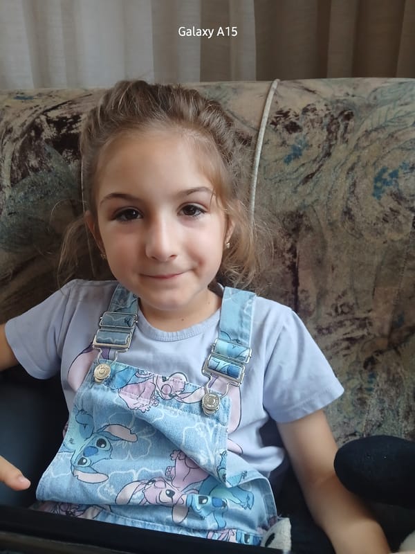 Young girl photographed on patterned sofa in Bulgarian village