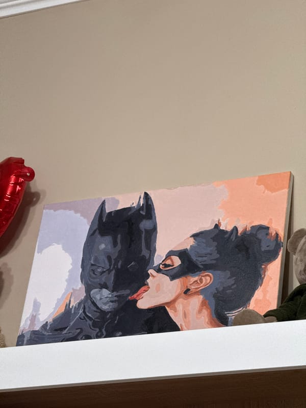 Indoor space displays Batman artwork and personal shelf items