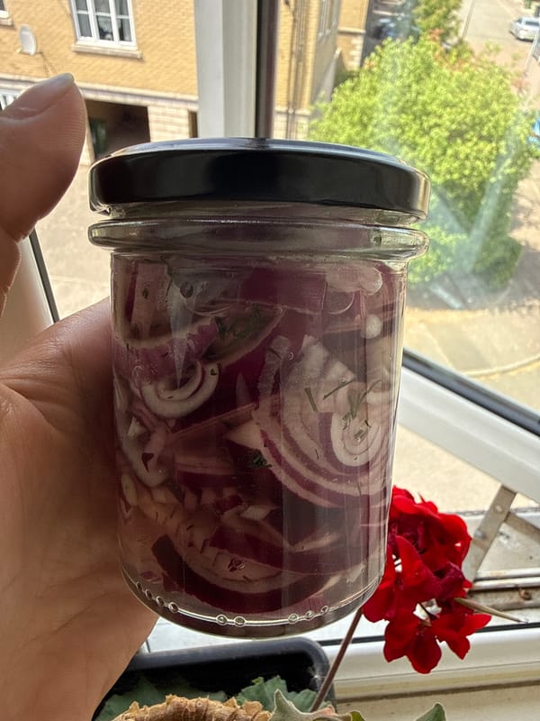 Person displays pickled onions jar near window in Great Yarmouth