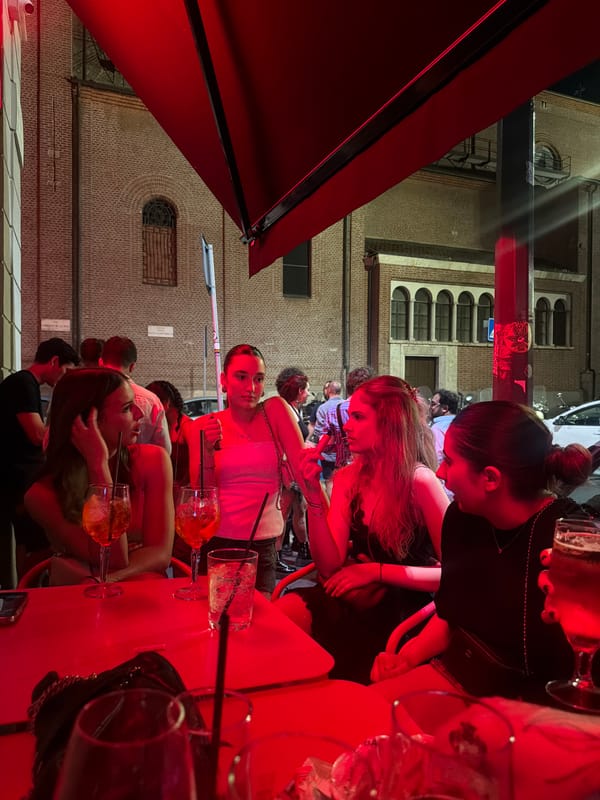 Evening drinks at a red-lit outdoor bar in Milan