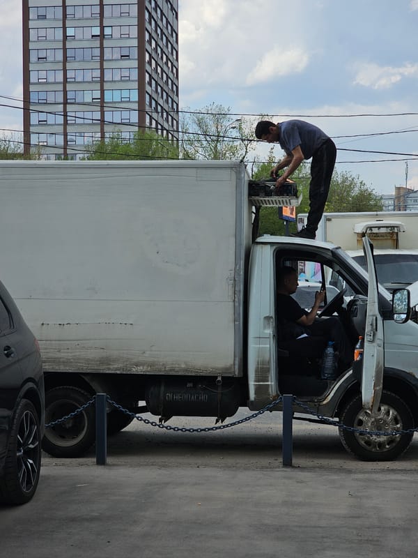 Two men service commercial truck in Moscow