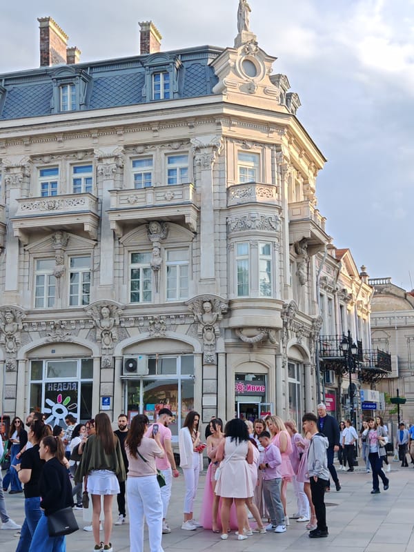 Crowd gathers in white and pink at Ruse square