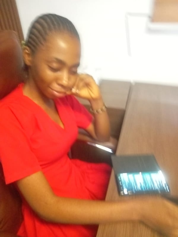 Woman in red dress observed at desk with tablet
