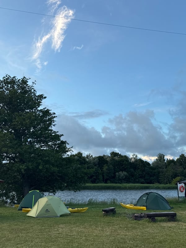 Camping and kite flying by the Gauja River at dusk
