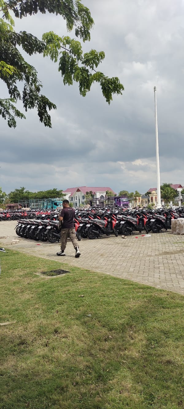 Motorcycles fill the lot outside a domed mosque in Lhoksukon