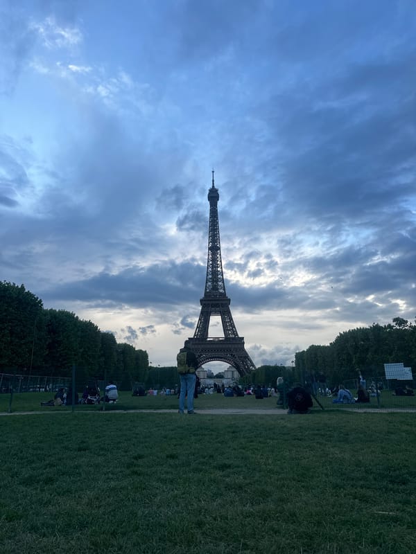 Person walks across Eiffel Tower lawn in Paris