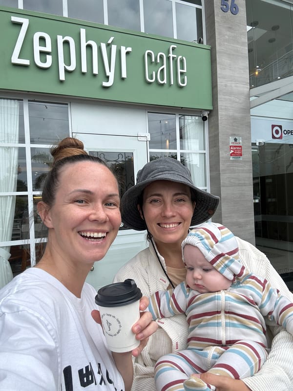 Women and baby share casual moment outside Florianópolis cafe