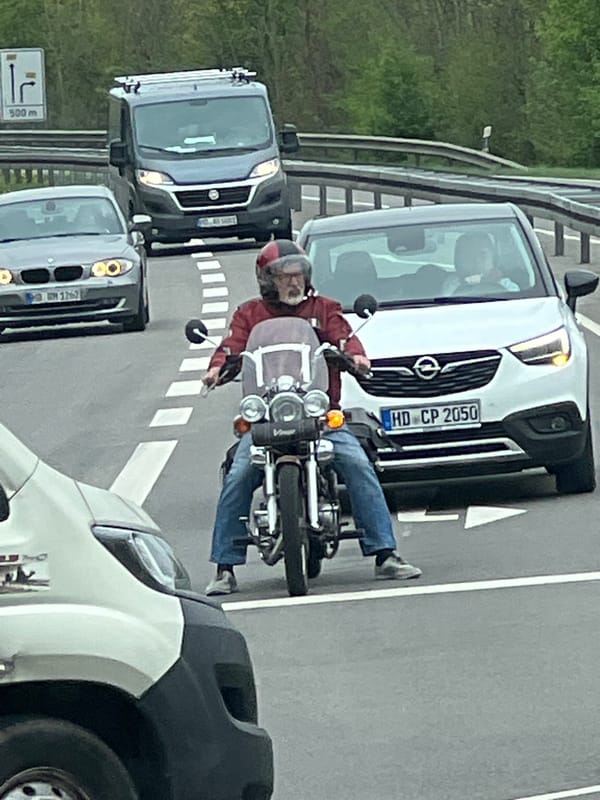 Motorcyclist in red jacket observed riding in traffic