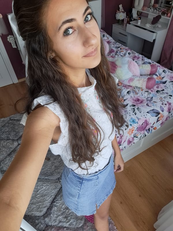Bedroom selfie session in white top and denim skirt.