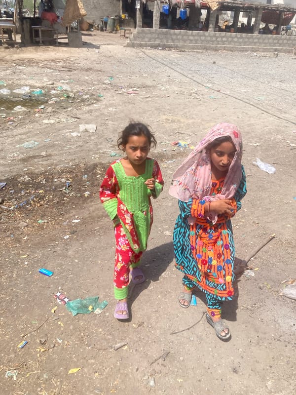 Two girls spotted on dusty ground in Uthal, Pakistan
