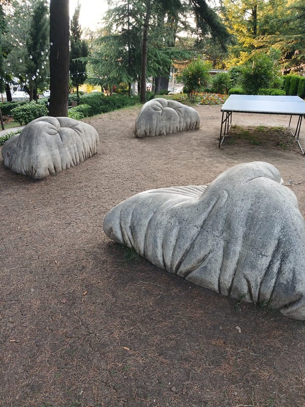 Afternoon in a blooming Telavi park with sculptures and roses