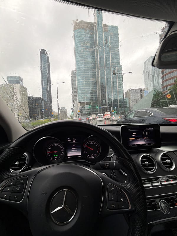 Rainy morning traffic captured from Mercedes in modern city