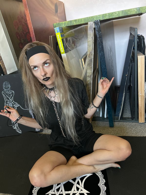 Artist works among artwork stacks in Cape Coral studio