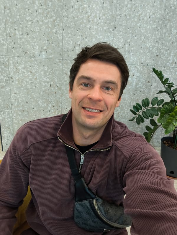 Smiling man in purple jacket observed indoors in Moscow