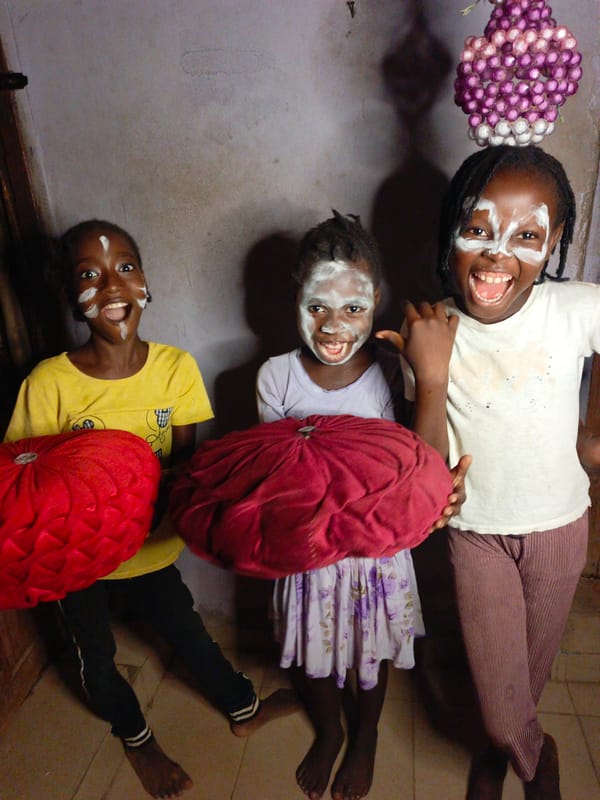 Children celebrate with traditional white face paint indoors