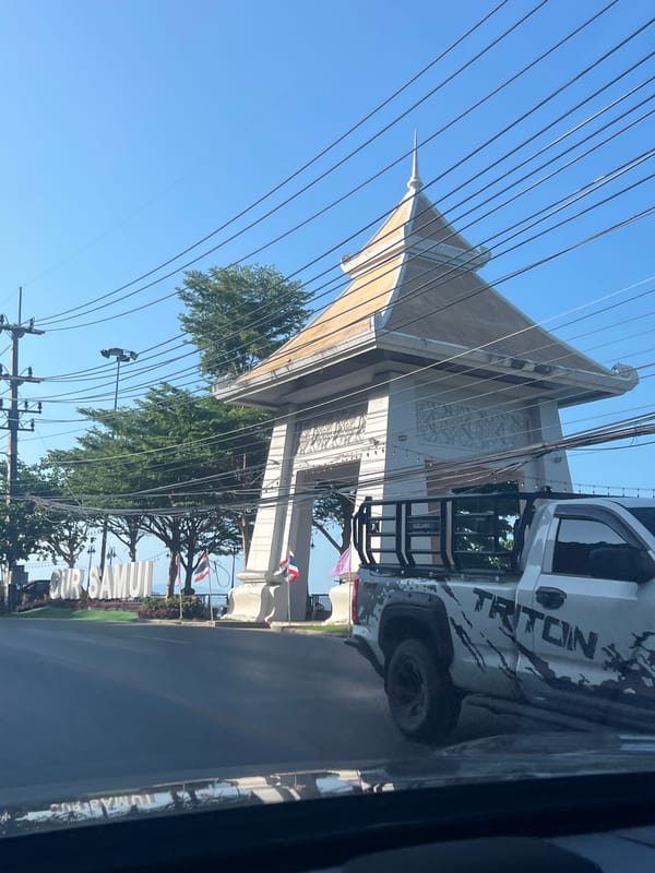 Ko Samui coastal road with ocean views and passing traffic