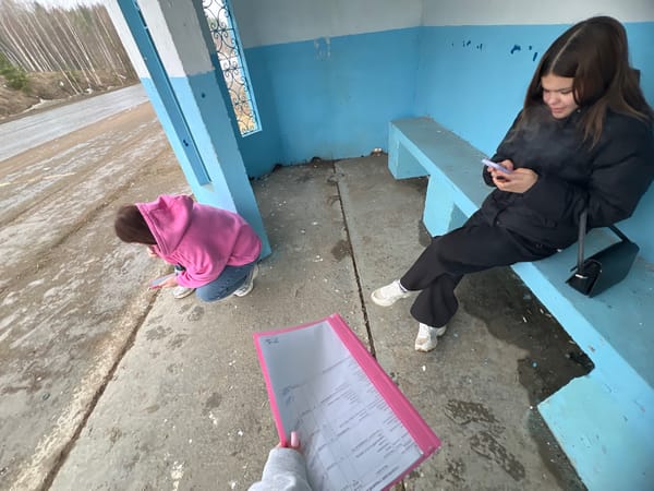 Young women wait at bus stop in Chaikovsky, Russia