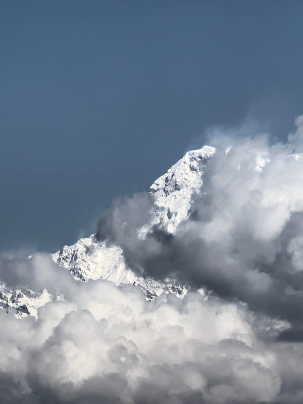 Snow-covered peaks photographed through clouds near Pokhara, Nepal