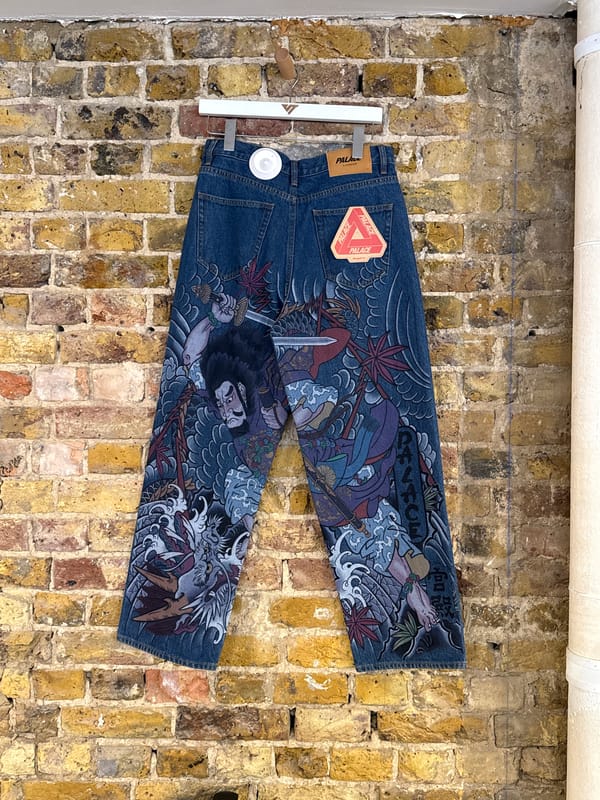 Japanese-decorated jeans displayed against brick wall in London