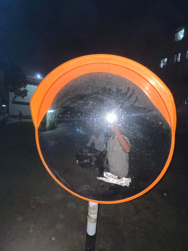 Person takes creative selfie in traffic mirror in Dhaka