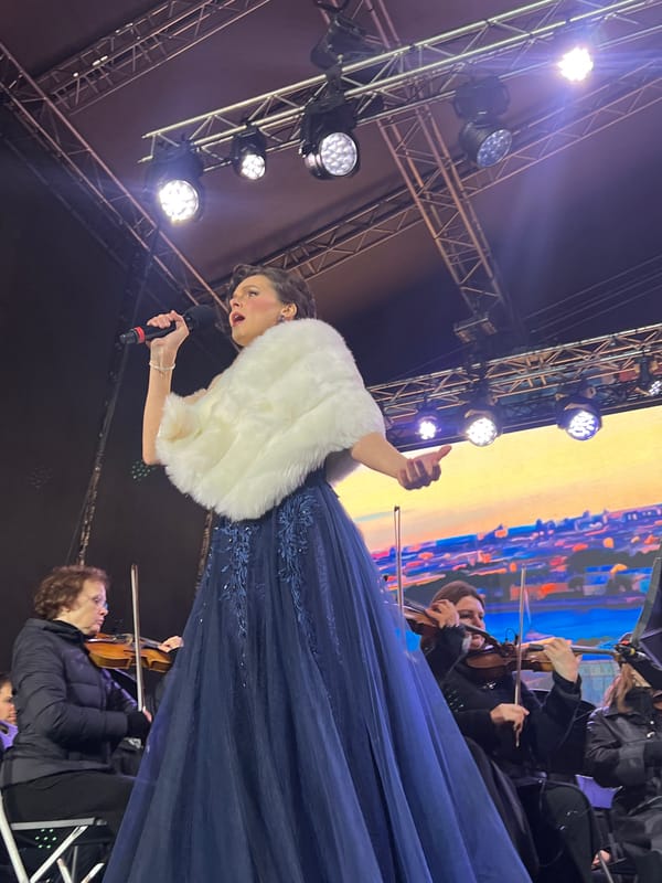 Orchestral performance features dual vocalists on outdoor stage