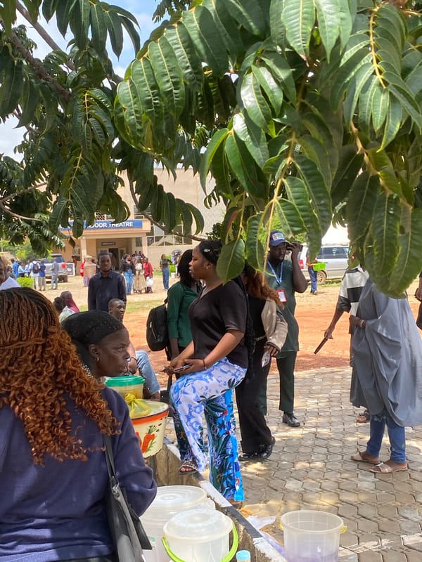 Campus pop-up event in Jos with vendors, auto-rickshaws, and crowds